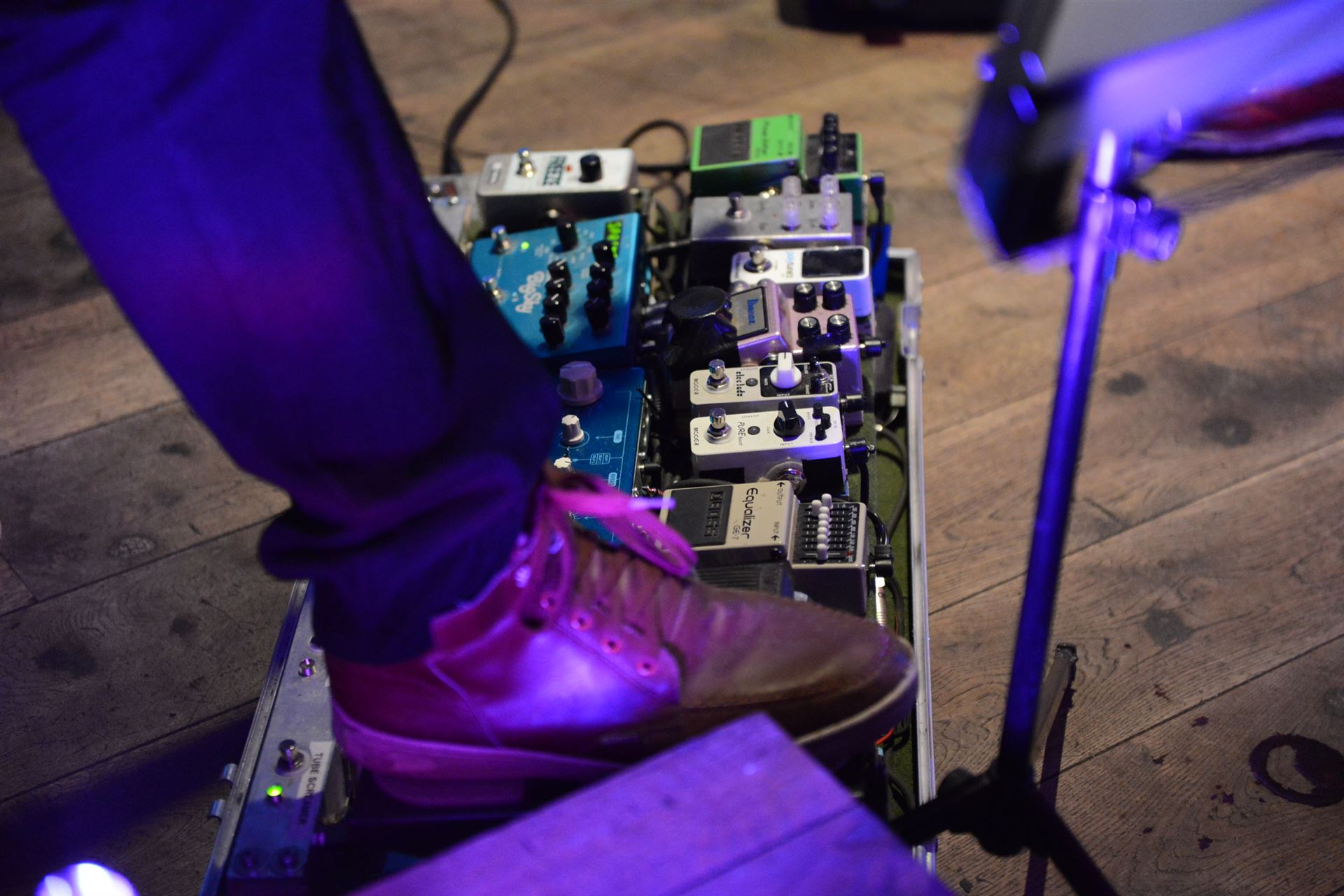 Nahaufnahme eines Gitarren-Pedalboards bei einem Konzert